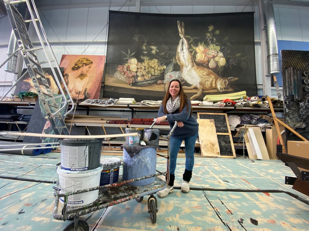 Nicole Küllmei leitet den Malsaal der Werkstätten des Theaters Magdeburg. Im Hintergrund ist eine der großformatigen Arbeiten zu sehen, an denen sie selbst mitgearbeitet hat.