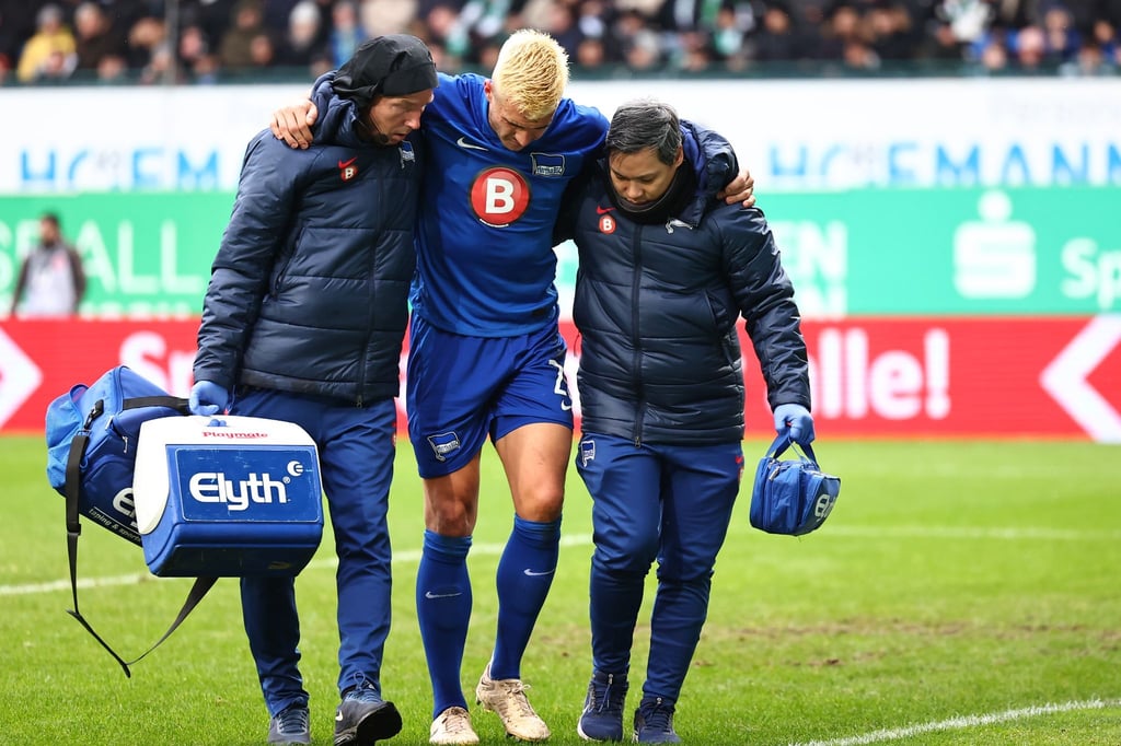 Marc Oliver Kempf (M) von Hertha BSC wird nach seinem Treffer zum 1:2 verletzt vom Platz begleitet.