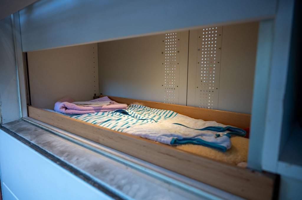 Das Fenster der Babyklappe ist geöffnet, Baby-Schlafsack, Handtuch, Decken liegen bereit.