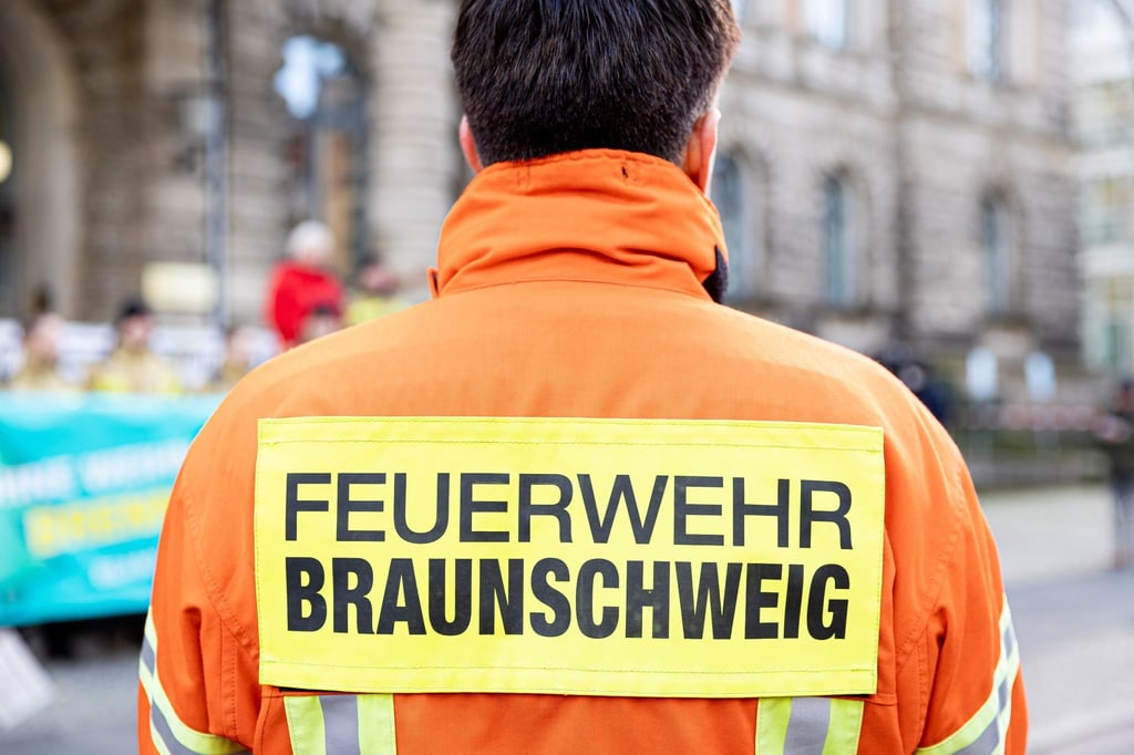 Der Schriftzug "Feuerwehr Braunschweig" ist auf der Einsatzkleidung eines Feuerwehrmanns zu lesen.