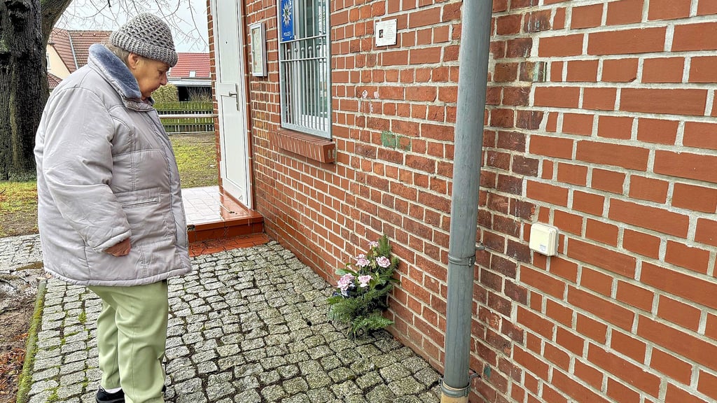 Annemarie Probst aus Parey legte anlässlich des 100. Geburtstages von Horst Avemann ein Blumengebinde vor der Erinnerungstafel nieder.