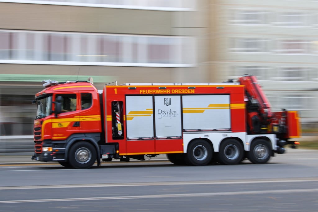 Ein Rüstwagen Kran der Berufsfeuerwehr Dresden fährt auf einer Straße zum Einsatz.