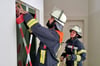 Kameraden der Havelberger Feuerwehr sperren  den Aufzug vorsorglich ab, bis die Betreiberfirma die Ursache  fürs Steckenbleiben  gefunden hat.