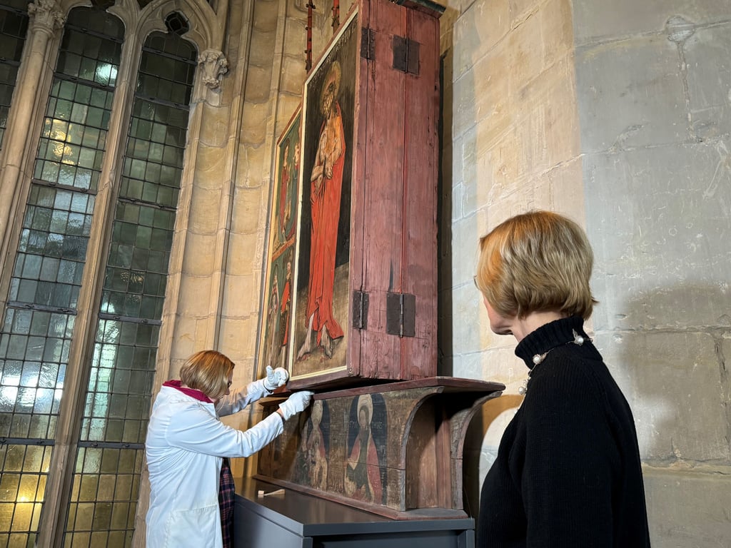 Restauratorin Christine Machate und Museumsleiterin Dr. Uta-Christiane Bergemann beim Schließen der mittelalterlichen Flügelaltäre im Kapitelsaal des Halberstädter Domschatzes.