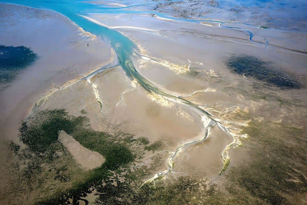 Ein Priel zieht sich durch das ostfriesische Wattenmeer.