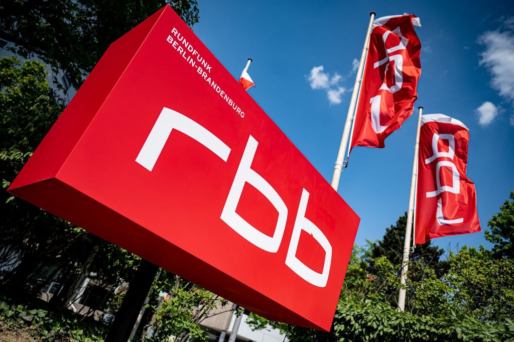 Ein Schild mit dem Logo des rbb steht vor dem Gebäude des Senders.