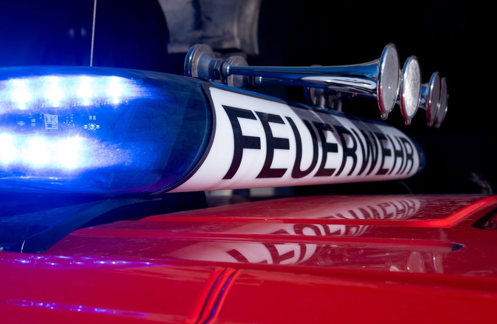 Ein Einsatzfahrzeug der Feuerwehr mit eingeschaltetem Blaulicht.