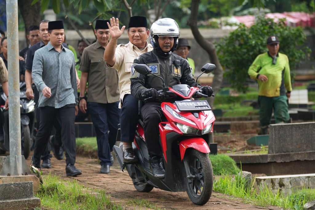 Prabowo Subianto wird von einem Polizisten zum Grab seines Vaters in Jakarta gefahren.
