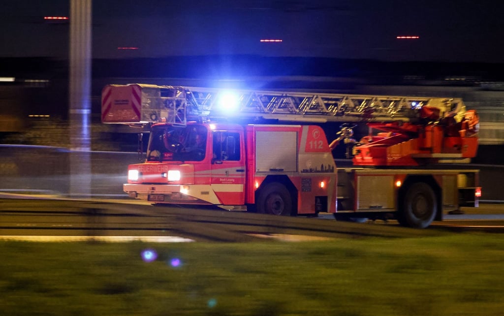 Ein Fahrzeug der Feuerwehr fährt mit Blaulicht und Martinshorn am Morgen durch Leipzig.