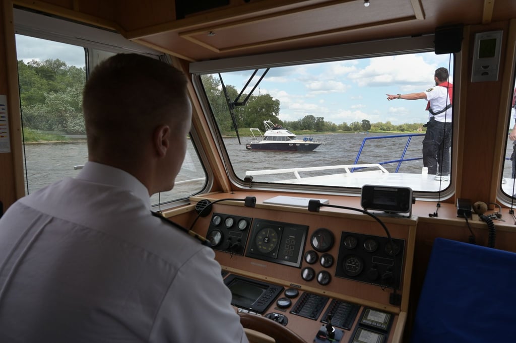Die Wasserschutzpolizei bedeutet einem Bootsführer beizudrehen und am Polizeiboot festzumachen.