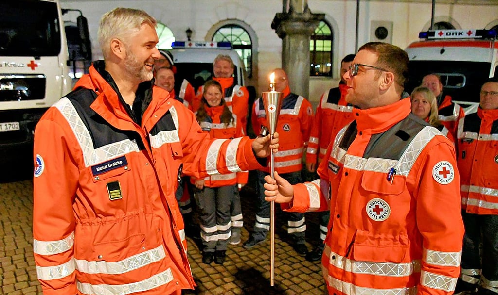 Markus Gratzke (li.) von der Haldensleber Wasserwacht des Deutschen Roten Kreuzes übergab das „Licht der Hoffnung und Menschlichkeit“ in Haldensleben an Gordon Westphal von der DRK-Bereitschaft.