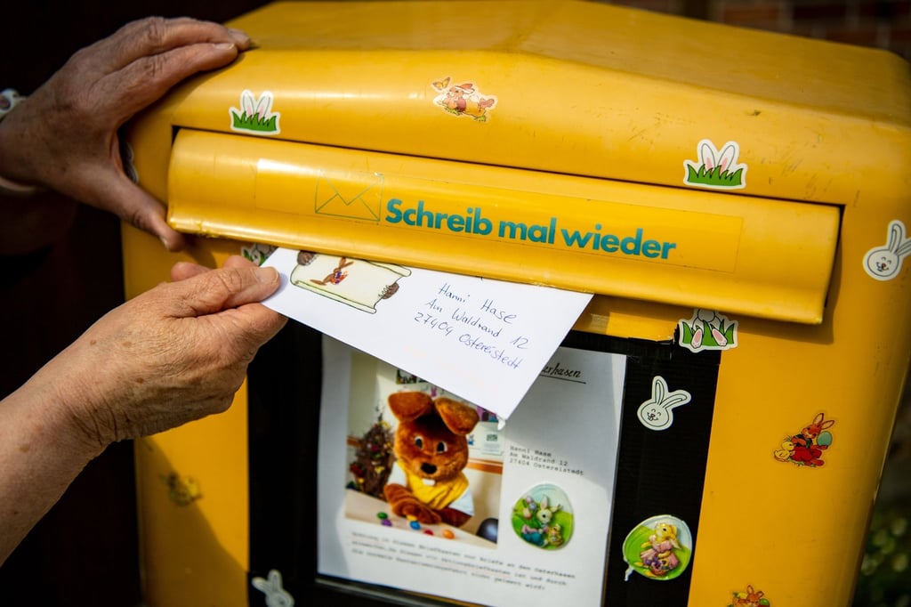Ein Brief, den ein Kind für den Osterhasen Hanni Hase geschrieben hat, wird in einen Briefkasten geworfen.