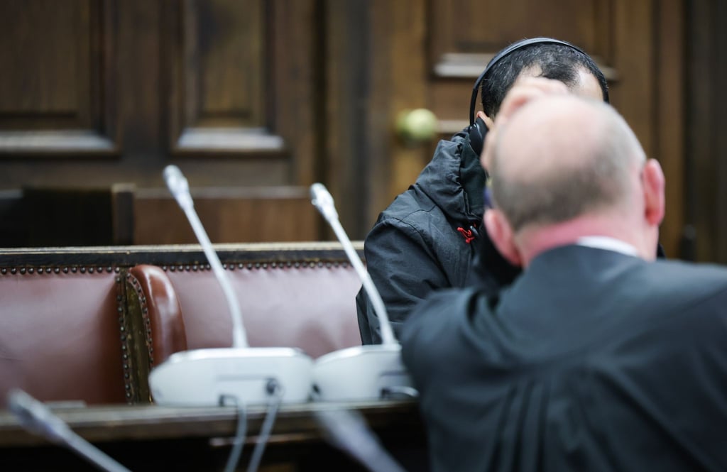 Einer der beiden Angeklagten (verdeckt) spricht mit seinem Anwalt Hannes Linke vor Prozessbeginn im Gerichtssaal des Strafjustizgebäudes.