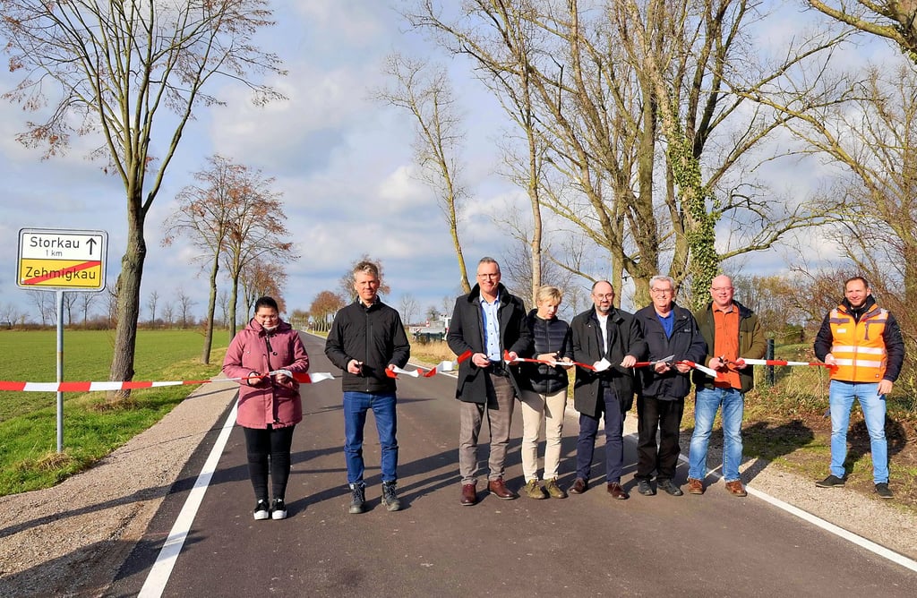 Ortschaftsrätin Charlott Ziehm (v. li.), Strabag -Niederlassungsleiter Oliver Faber, Andreas Rößler, Christine Döring, Thomas Schneider, Ortschaftsrat Günter Lorenz, Norbert Müller als interessierter Bürger und Bauleiter Dennis Düben durchtrennen am Dienstagnachmittag symbolisch das Absperrband auf der Straße Richtung Storkau.