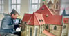 Thomas Sommerfeld, Mitarbeiter in Wernigerodes Bürger- und Miniaturenpark „Kleiner Harz“, gibt dem  neuen Dach der Halberstädter Martinikirche einen Farbanstrich.