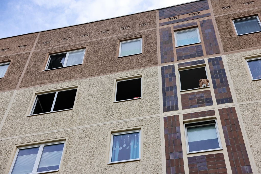 Mit einem Teddybären ist nach einem Brand ein geöffnetes Fenster einer Wohnung im Leipziger Stadtteil Paunsdorf blockiert.