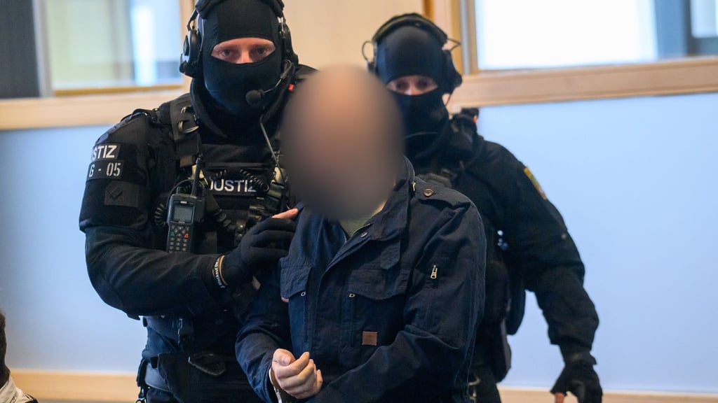 Justitzbeamte führen den Angeklagten Stephan Balliet in den Gerichtssaal.