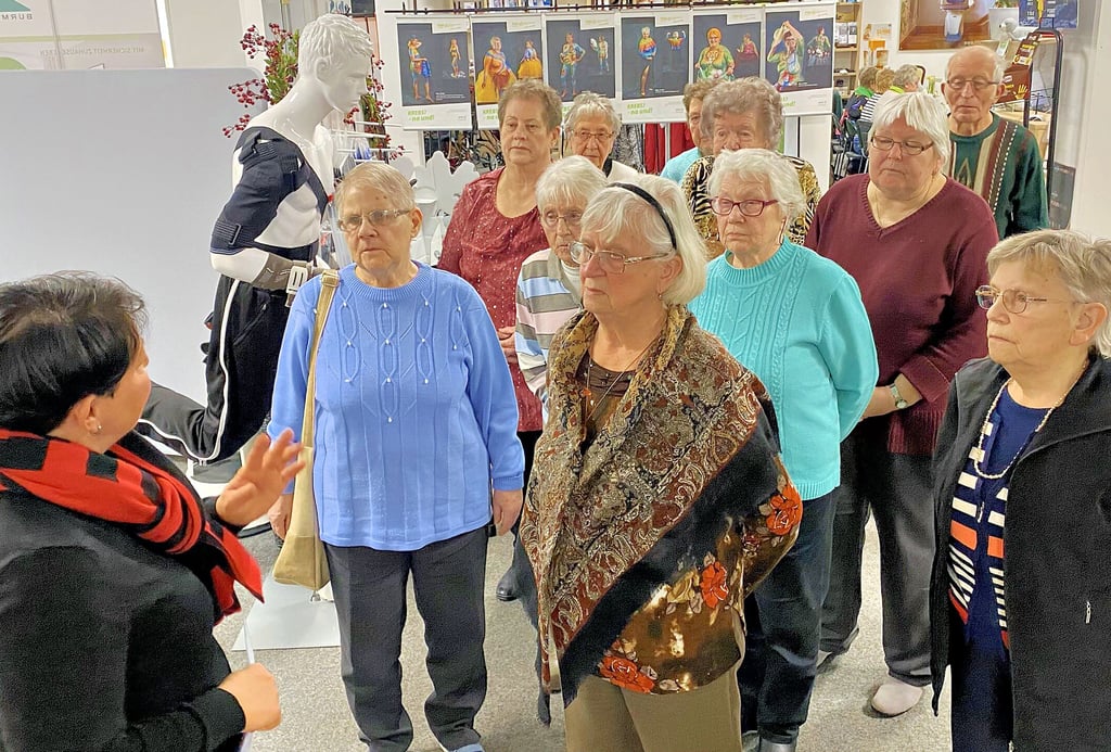 Solveig Barthel vom Jessener Sanitätshaus SoNa führt eine erste Gruppe von Mitgliedern der Frauenselbsthilfe Krebs durch die Räume des Jessener Unternehmens. Im Hintergrund ist die Fotoausstellung zu sehen, für die sich Mitgliederinnen der Gruppe einer Bodypainting-Session hingaben und nun im Foto präsentieren.