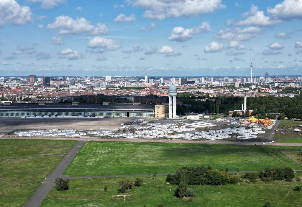 Die sogenannten Tempohomes, Wohncontainer für Geflüchtete, stehen vor dem früheren Hangar auf dem Tempelhofer Feld. Das riesige Flugfeld vom ehemaligen Flughafen Tempelhof ist vor dem Hintergrund der Wohnungsnot wieder im Gespräch.