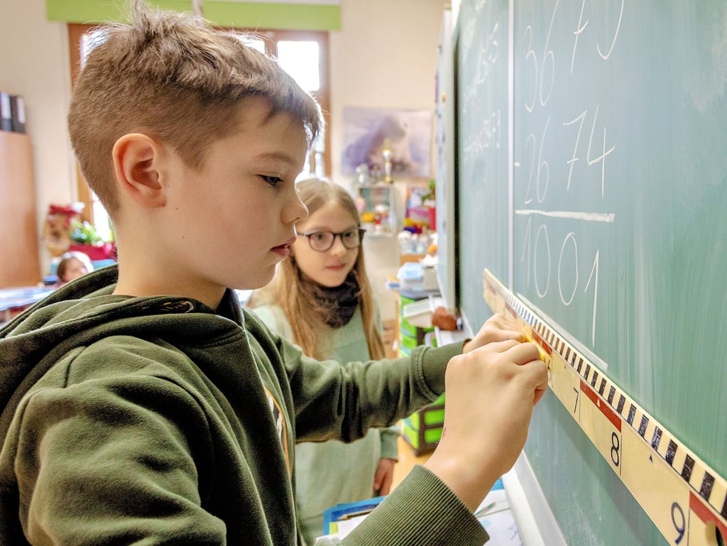 Jimmy (links) und Johanna lösen eine Subtraktionsaufgabe an einer der neuen Tafeln in der Grundschule Annaburg.