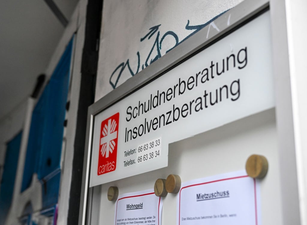 Eine Schuldnerberatung und Insolvenzberatung der Caritas ist an einem Eingang in der Schönhauser Allee in Pankow ausgeschildert.