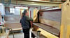 Tischlermeister und Restaurator Hagen Siedler streicht die aufgearbeiteten Bänke aus der Wuster Kirche mit einer Leinölfarbe. 