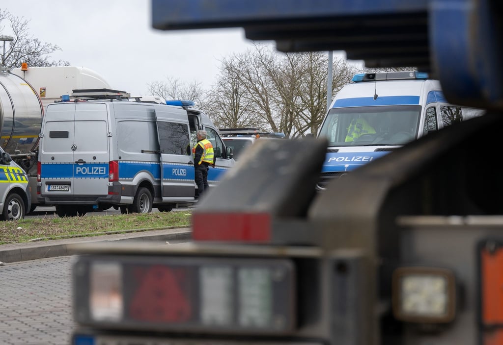 Polizeifahrzeuge stehen neben Lastwagen auf dem Parkplatz Plötzetal an der A14.