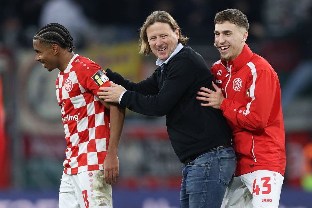 Der Mainzer Trainer Bo Henriksen und seine Spieler Leandro Barreiro (l) und Brajan Gruda freuen sich nach dem Schlusspfiff über den Sieg.