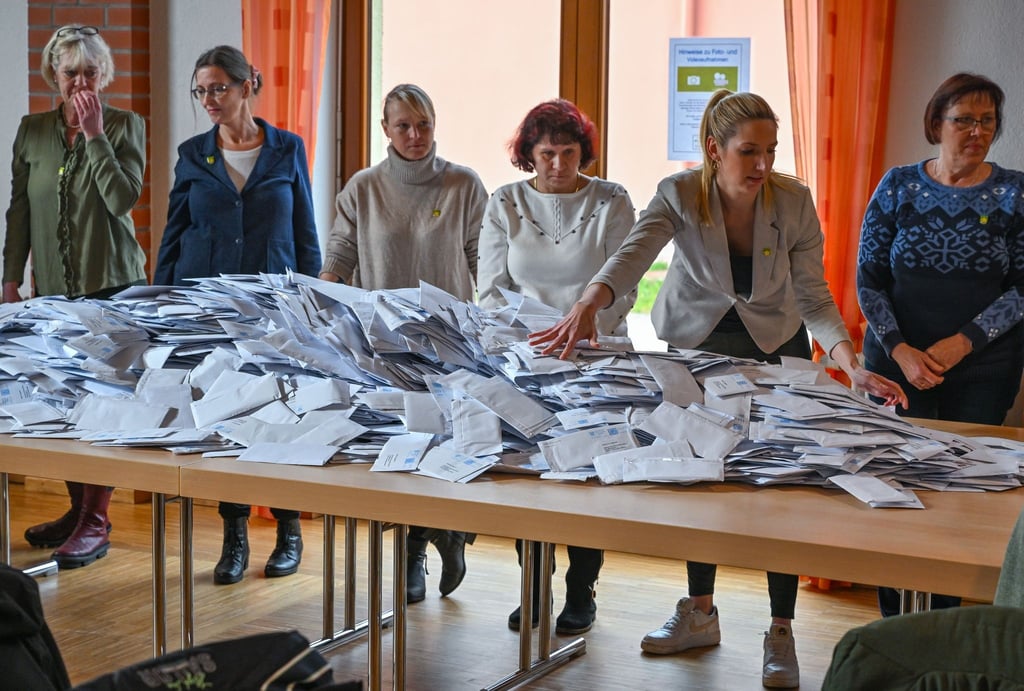 Mitarbeiterinnen der Gemeinde Grünheide beginnen mit der Auszählung der Briefwahl.