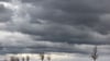 Dunkle Wolken ziehen über eine Baumallee in Arnstadt.