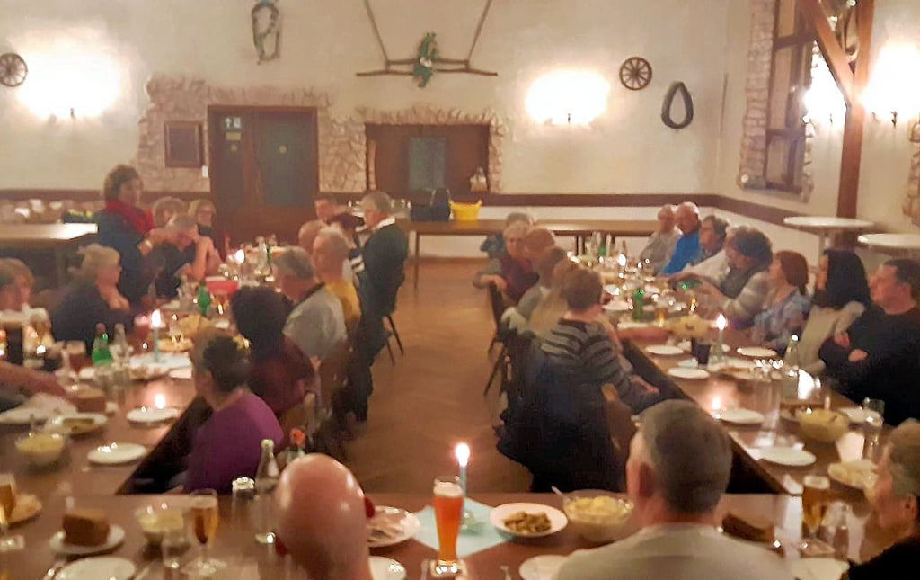In Saal der Gaststätte wird der große Tisch feierlich für die Gäste gedeckt.