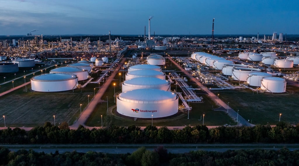 Hinter dem beleuchteten Tanklager ragen die Anlagen der Total-Raffinerie und des Chemieparks in die Höhe.