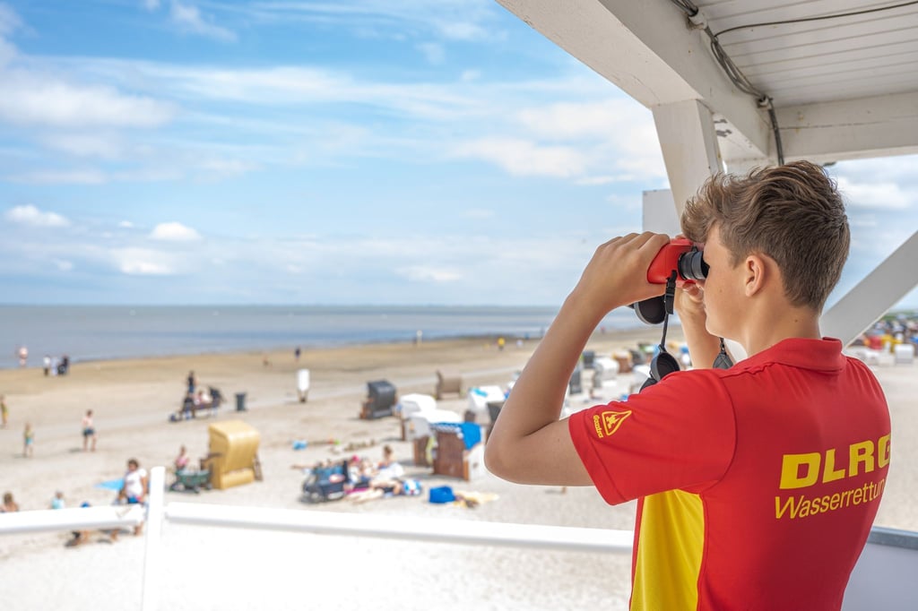 Peter von der DLRG-Wasserrettung steht auf einem Turm am Badestrand von Dangast.