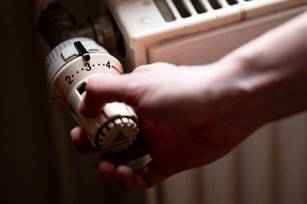 Eine Person benutzt einen alten Heizkörper in einer Berliner Altbauwohnung.