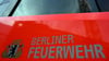 Der Schriftzug „Berliner Feuerwehr“ und das Wappen Berliner Feuerwehr stehen auf der Tür eines Feuerwehrfahrzeuges.