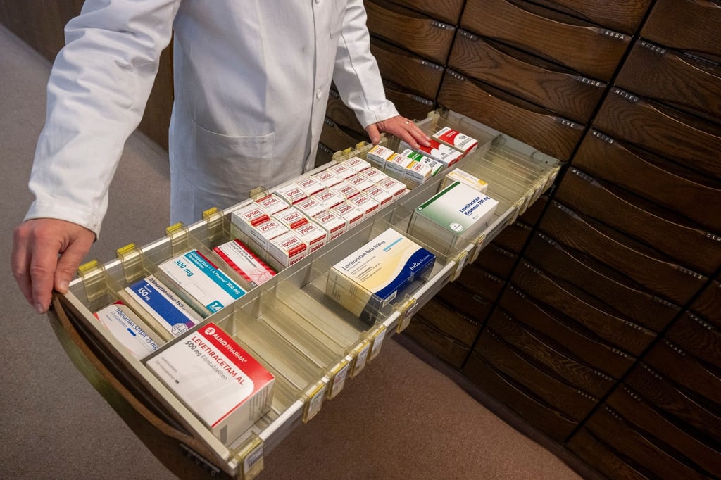 Ein Apotheker schaut in einen Medikamentenschrank.