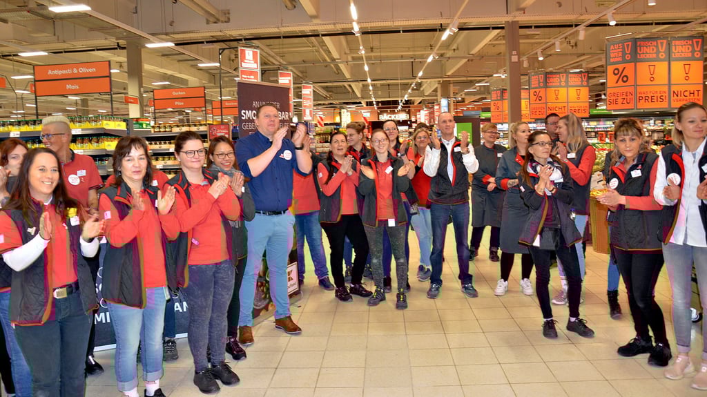 Kaufland-Mitarbeiter applaudieren zur Eröffnung per Scherenschnitt und freuen sich auf die ersten Kunden im neuen Markt in Staßfurt.