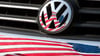 Die US-Fahne spiegelt sich in Logo und Kühlergrill eines Volkswagen-Fahrzeugs.