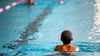 Ein Kind schwimmt in einem Schwimmbad.