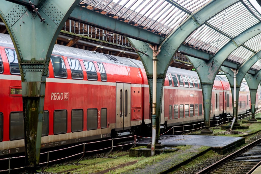 Ein Regional-Express der Deutschen Bahn steht an einem Bahnsteig in der historischen Gleishalle.