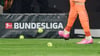 Dortmunds Torwart schießt Tennisbälle vom Platz, die Fans aus Protest auf das Spielfeld geworfen haben.