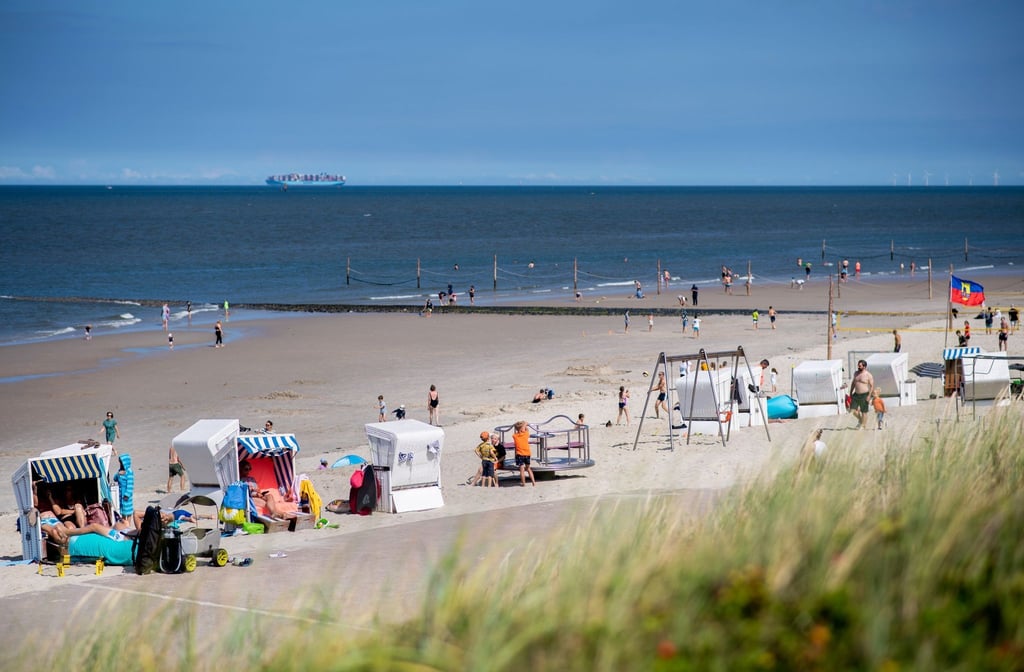 Zahlreiche Touristen sitzen bei sonnigem Wetter in Strandkörben am Strand der Insel Wangerooge.