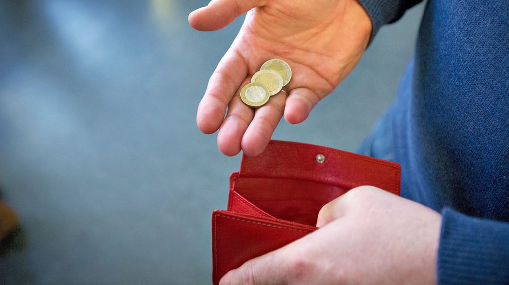 Eine Frau hält ein Portemonnaie mit Kleingeld – auch bei Berufsbetreuern ist oftmals Ebbe in der Kasse.