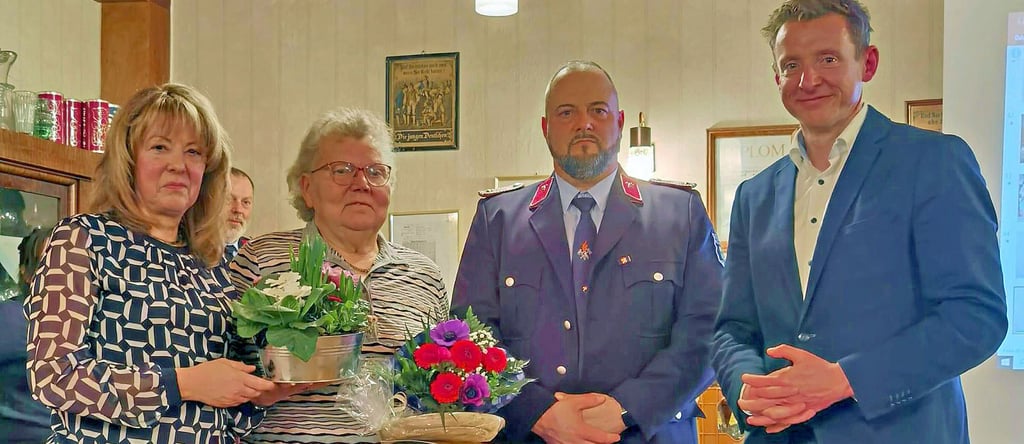 Thekla Möws (links), Enrico Mertynink und Andreas Brohm (rechts) gratulieren Resi Müller zu 60 Jahren Feuerwehrmitgliedschaft.
