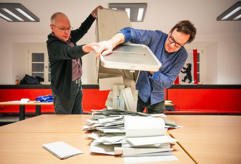 Wahlhelfer leeren bei der Stimmauszählung im Carl von Ossietzky-Gymnasium im Wahllokal 317 die Wahlurnen aus.