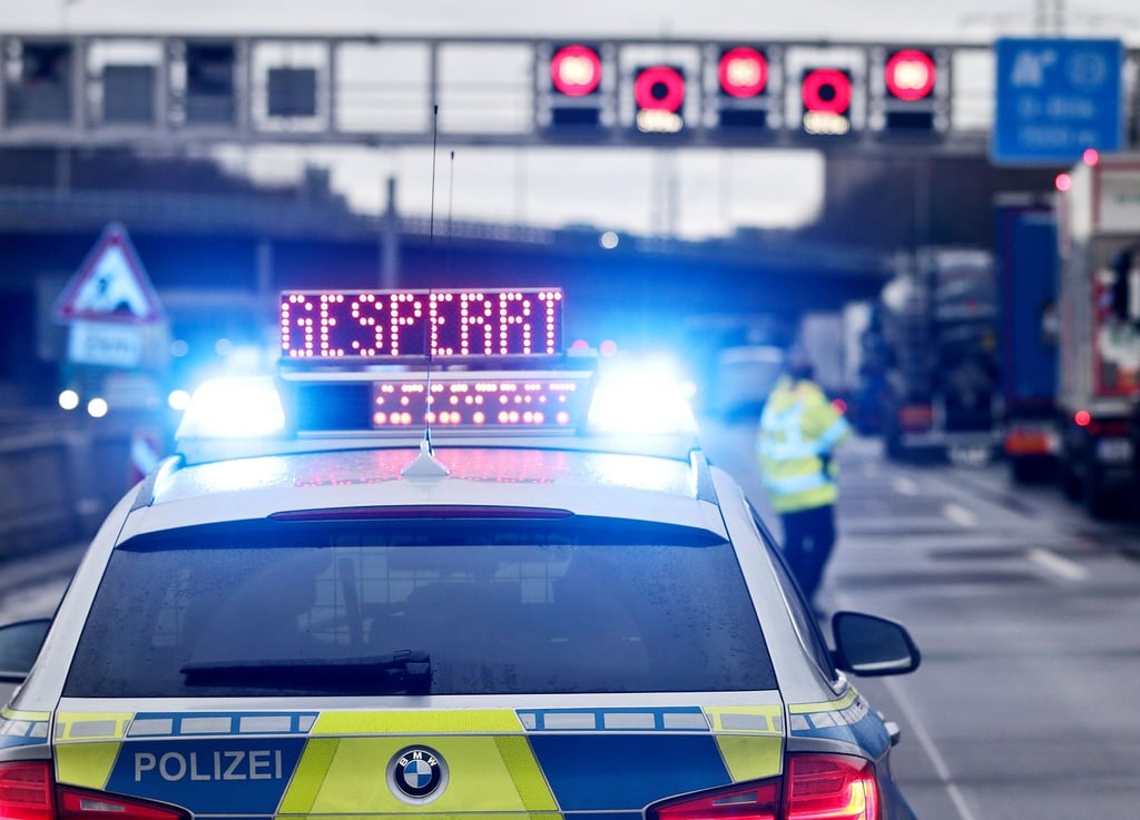 Auf einem Polizeifahrzeug leuchtet die Aufschrift „Gesperrt“.