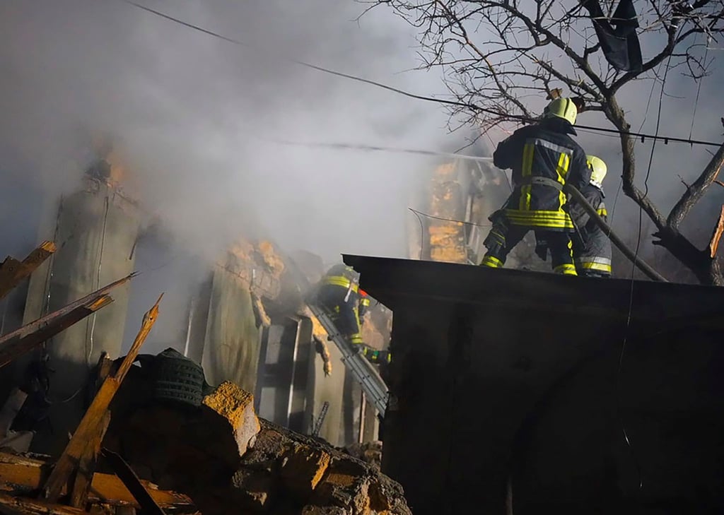 Feuerwehrleute arbeiten an einem brennenden Gebäude nach einem russischen Angriff in Odessa.