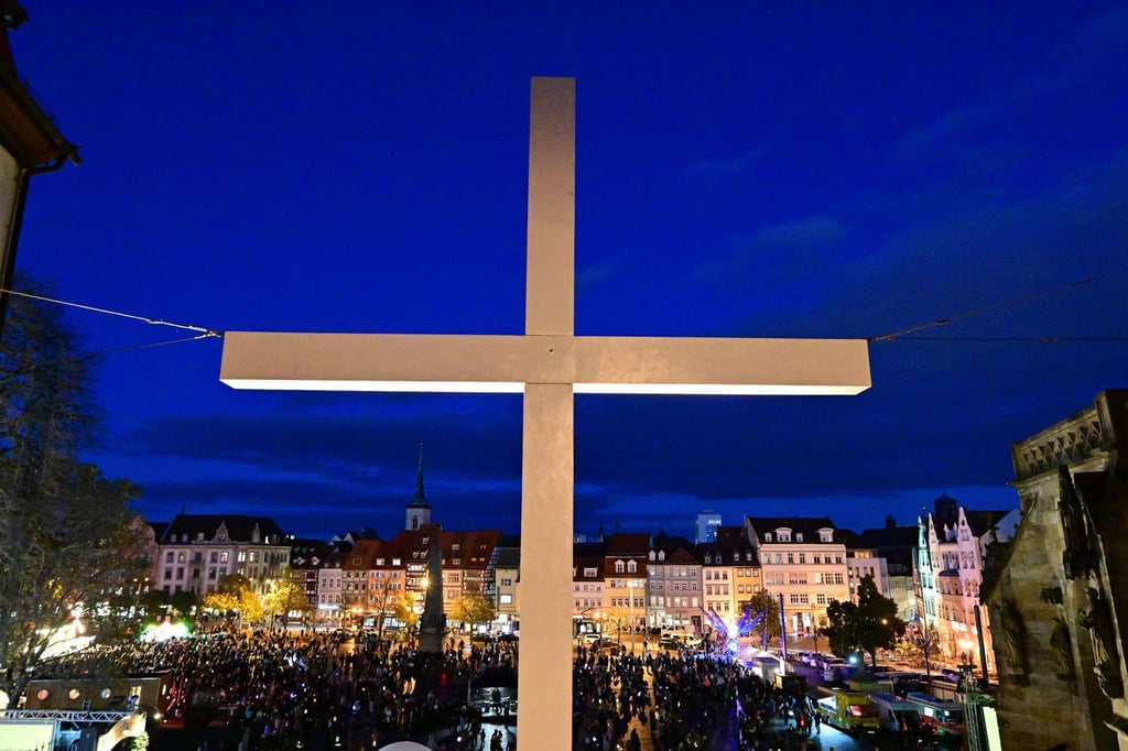 Teilnehmer beim ökumenischen Martinsfest stehen auf dem Erfurter Domplatz.