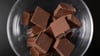 Eine Schale mit Schokolade steht auf einem Couchtisch. Der steigende Kakao-Preis könnte bald auch Auswirkungen auf die Schokolade im Supermarkt haben.