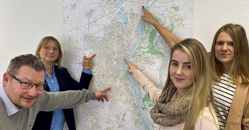 Adam Peter Jarzombek (von links), Madlen Schipp, Stefanie Garbe und Aileen Borris deuten auf dem Stadtplan auf die Regionen in Magdeburg, in denen sie für die Betreuung von Unternehmen zuständig sind.